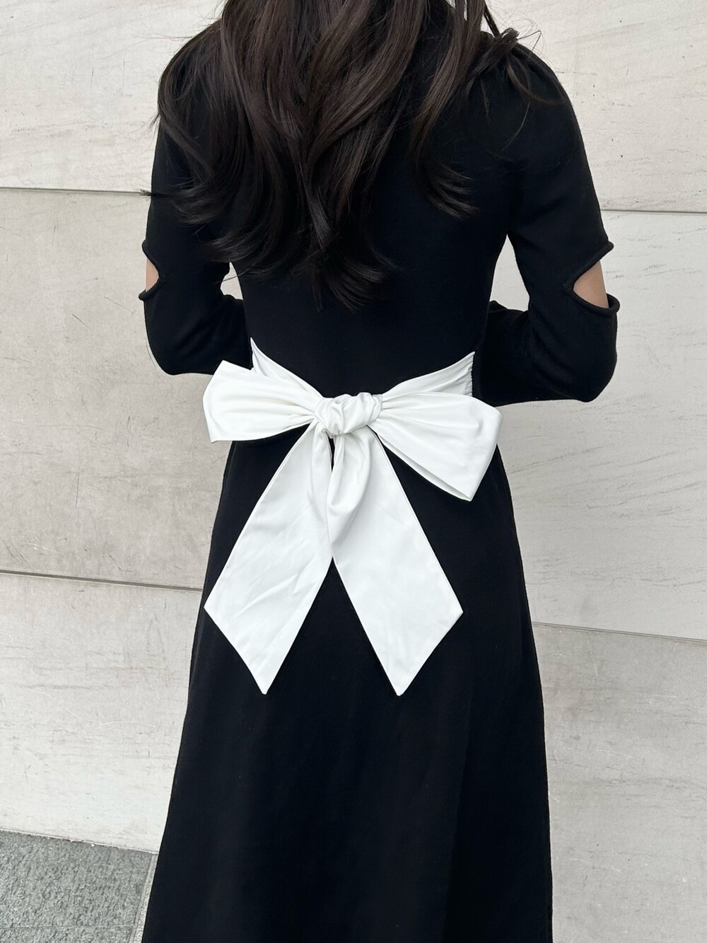 その他のブーツ、ブラック系のワンピース、ホワイト系のショルダーバッグを着用したレディースの冬コーディネートの4枚目の写真