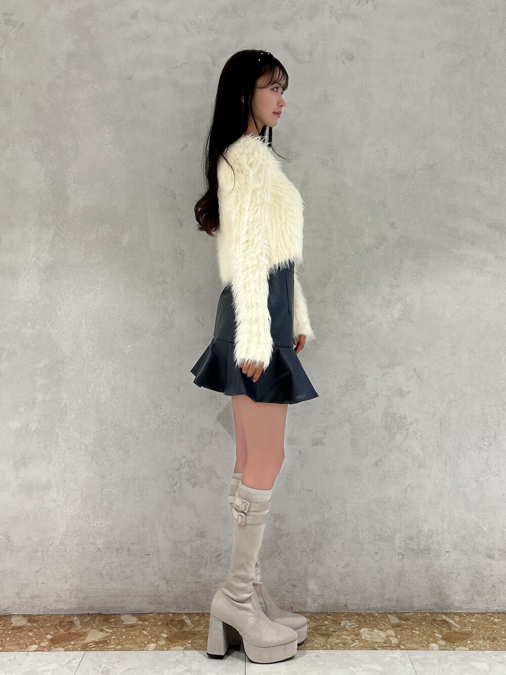 ホワイト系のカーディガン/ボレロ、ホワイト系のニット/セーター、ブルー系のスカートを着用したレディースの秋コーディネートの2枚目の写真