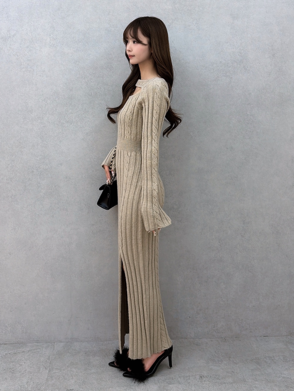 ベージュ系のワンピース、ブラック系のハンドバッグ、ブラック系のサンダルを着用したレディースの冬コーディネートの3枚目の写真