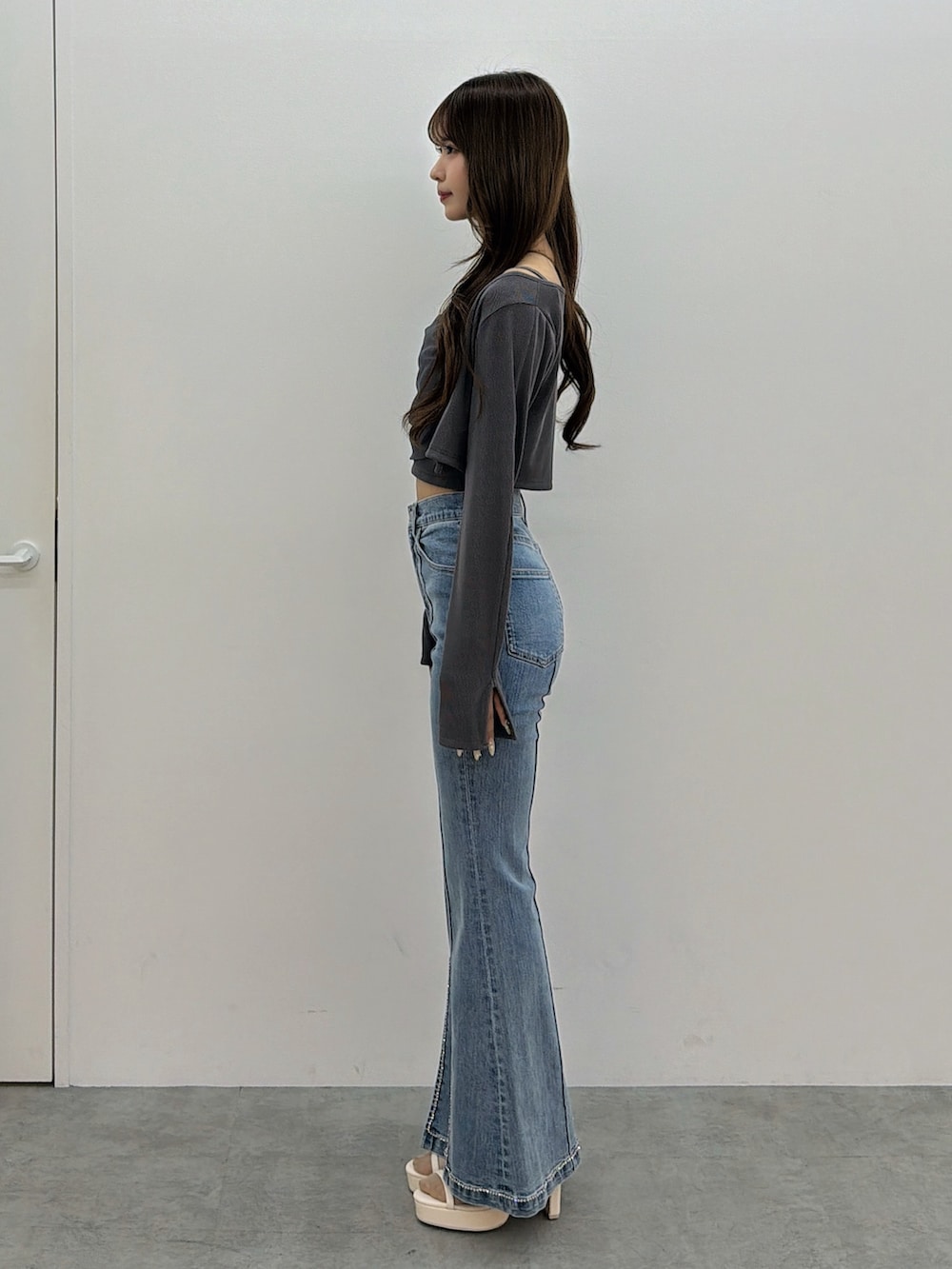 ブルー系のデニムパンツ、グレー系のTシャツ/カットソー、ホワイト系のサンダルを着用したレディースの春コーディネートの3枚目の写真