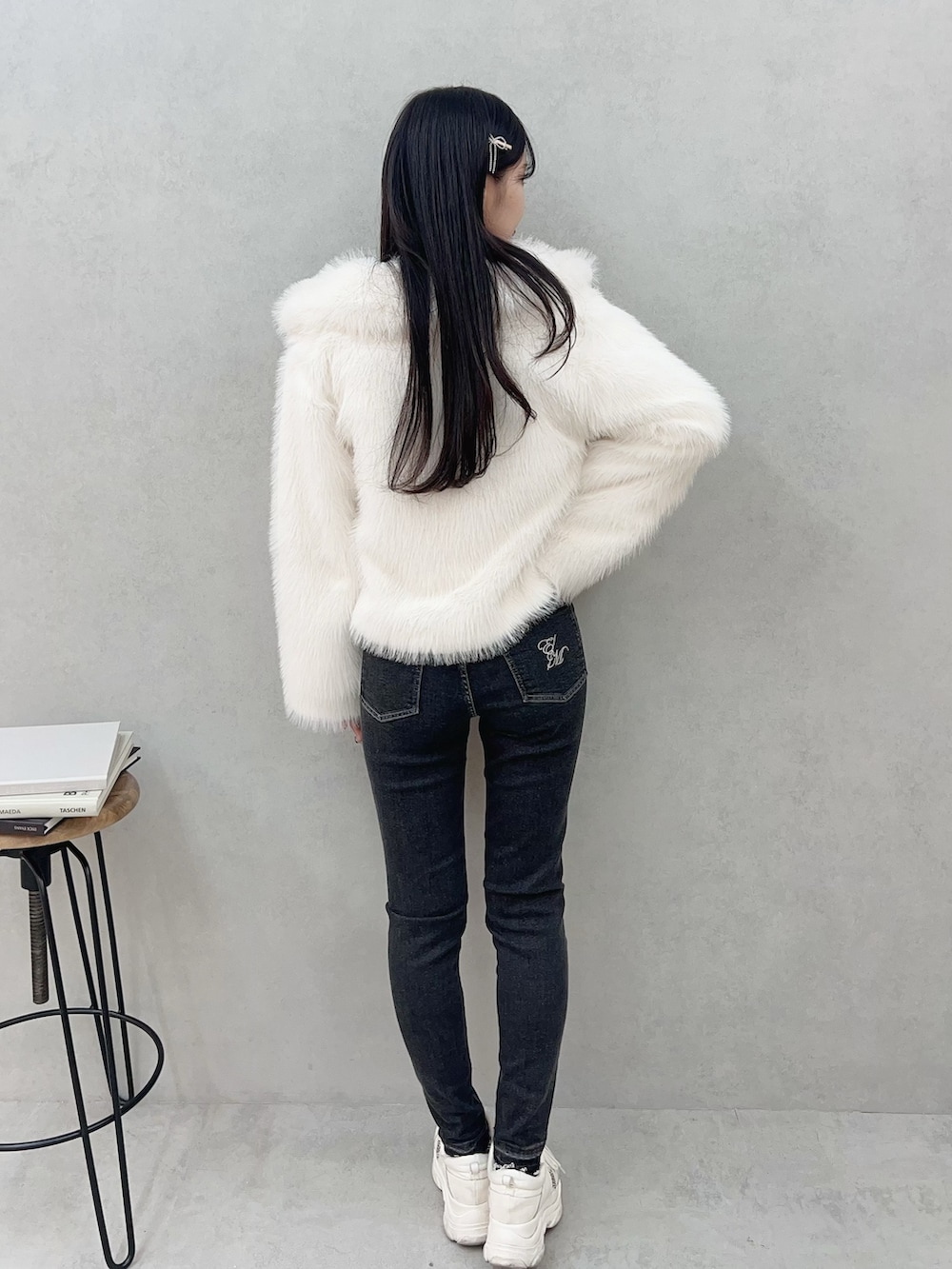 ホワイト系のその他アウター、ブラック系のデニムパンツ、ホワイト系のTシャツ/カットソーを着用したレディースの冬コーディネートの4枚目の写真