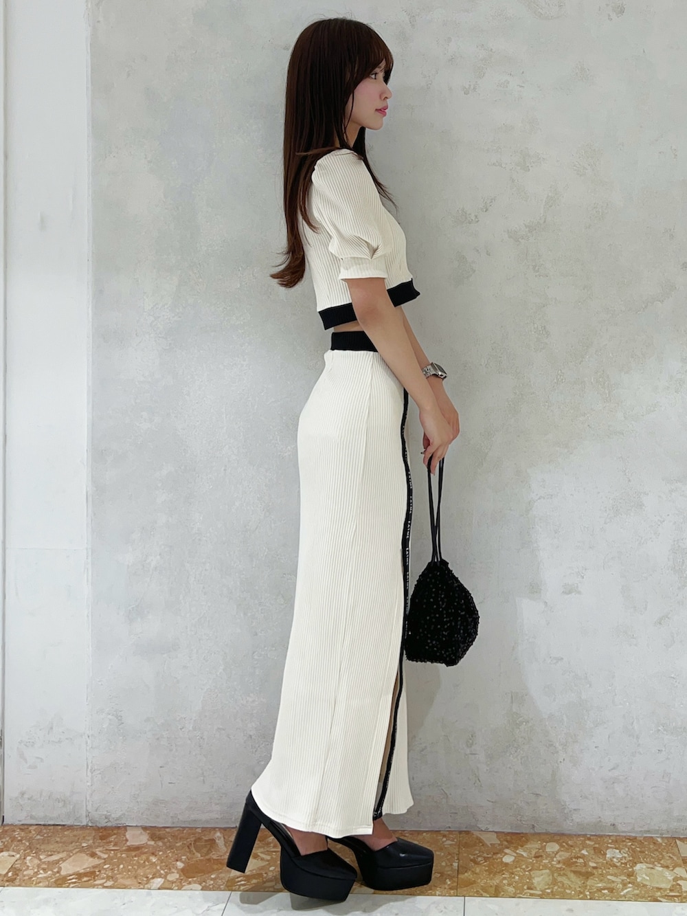 ホワイト系のTシャツ/カットソー、ホワイト系のスカート、ブラック系のハンドバッグを着用したレディースの夏コーディネートの2枚目の写真