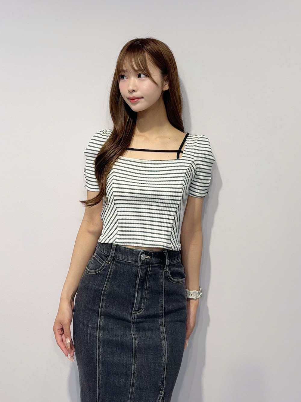 ブラック系のデニムスカート、その他のTシャツ/カットソー、ブラック系のサンダルを着用したレディースの春コーディネートの6枚目の写真