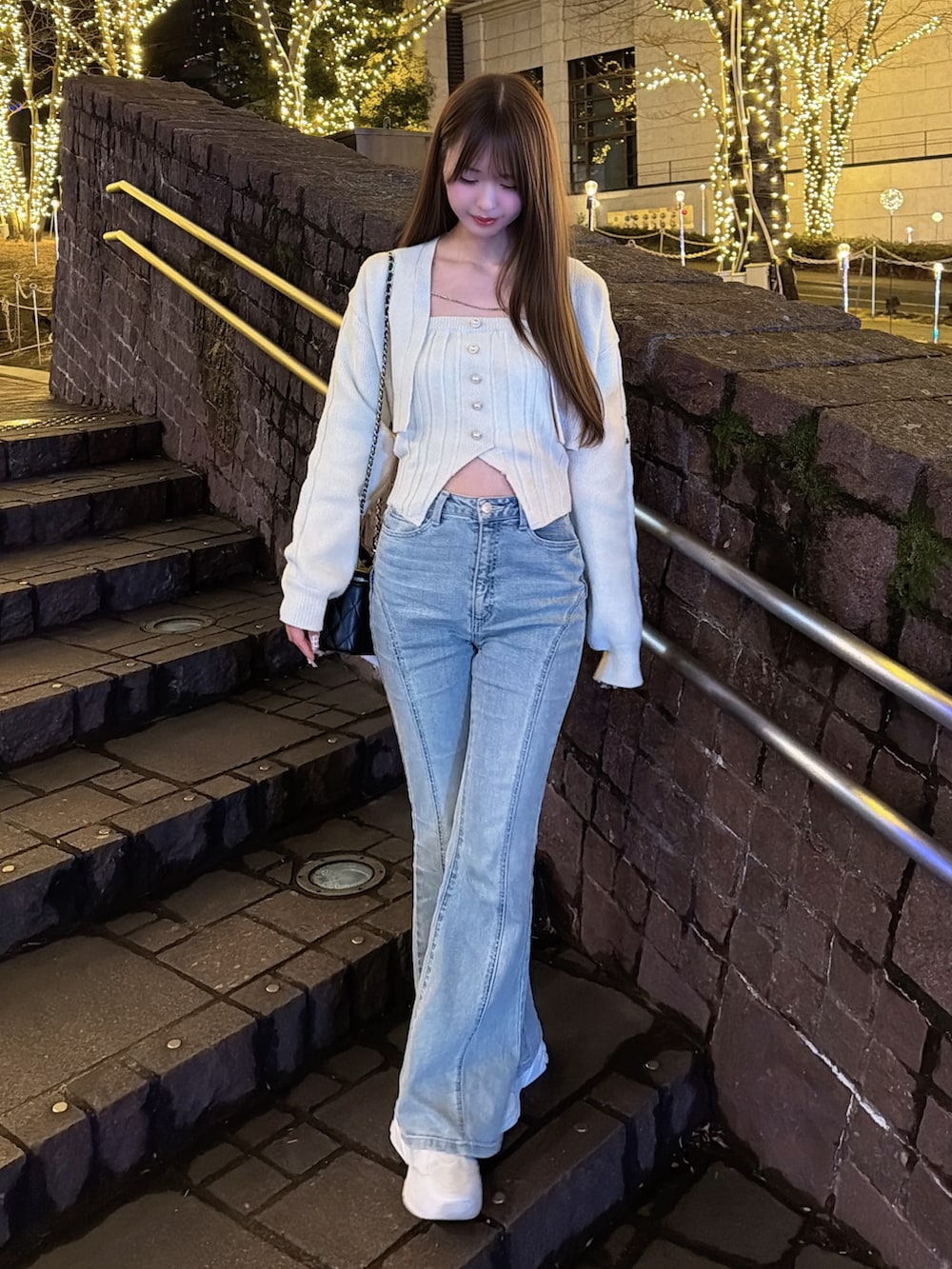 イエロー系のニット/セーター、ブルー系のデニムパンツを着用したレディースの冬コーディネートの2枚目の写真