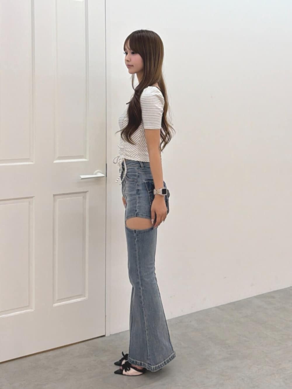 ブルー系のデニムパンツ、ブラック系のハンドバッグ、その他のパンプスを着用したレディースの夏コーディネートの3枚目の写真