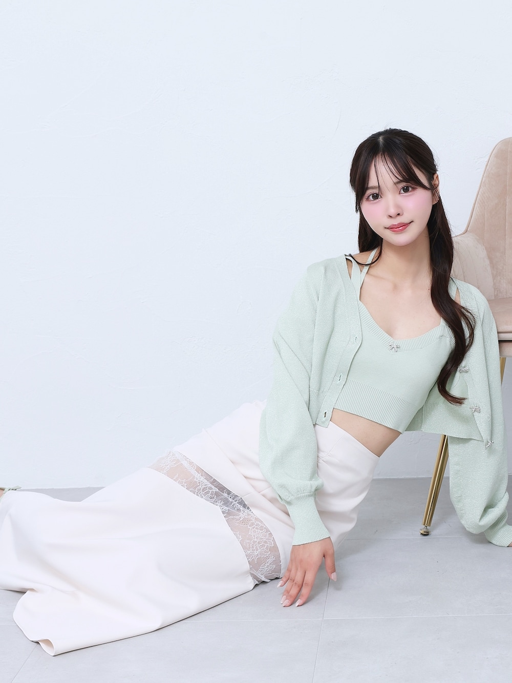 ホワイト系のスカート、グリーン系のニット/セーター、グリーン系のサンダルを着用したレディースの春コーディネートの4枚目の写真