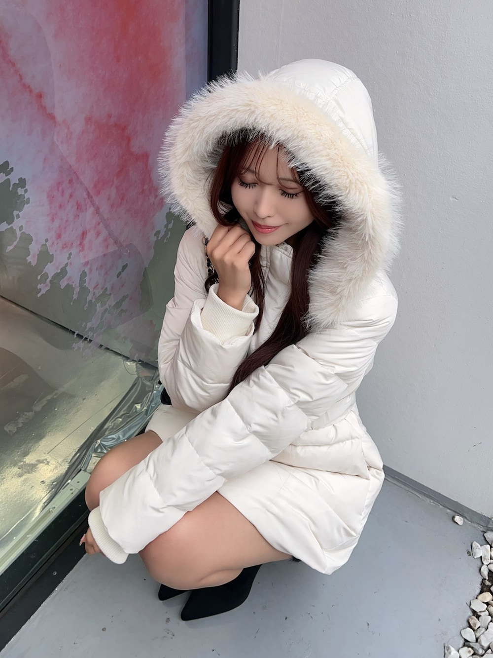 ホワイト系のダウンジャケット/コート、ブラック系のブーツ、ブラック系のハンドバッグを着用したレディースの秋コーディネートの8枚目の写真