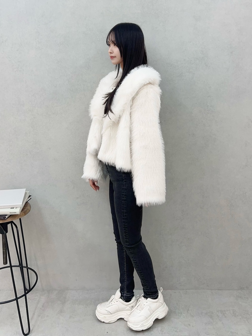 ホワイト系のその他アウター、ブラック系のデニムパンツ、ホワイト系のTシャツ/カットソーを着用したレディースの冬コーディネートの3枚目の写真