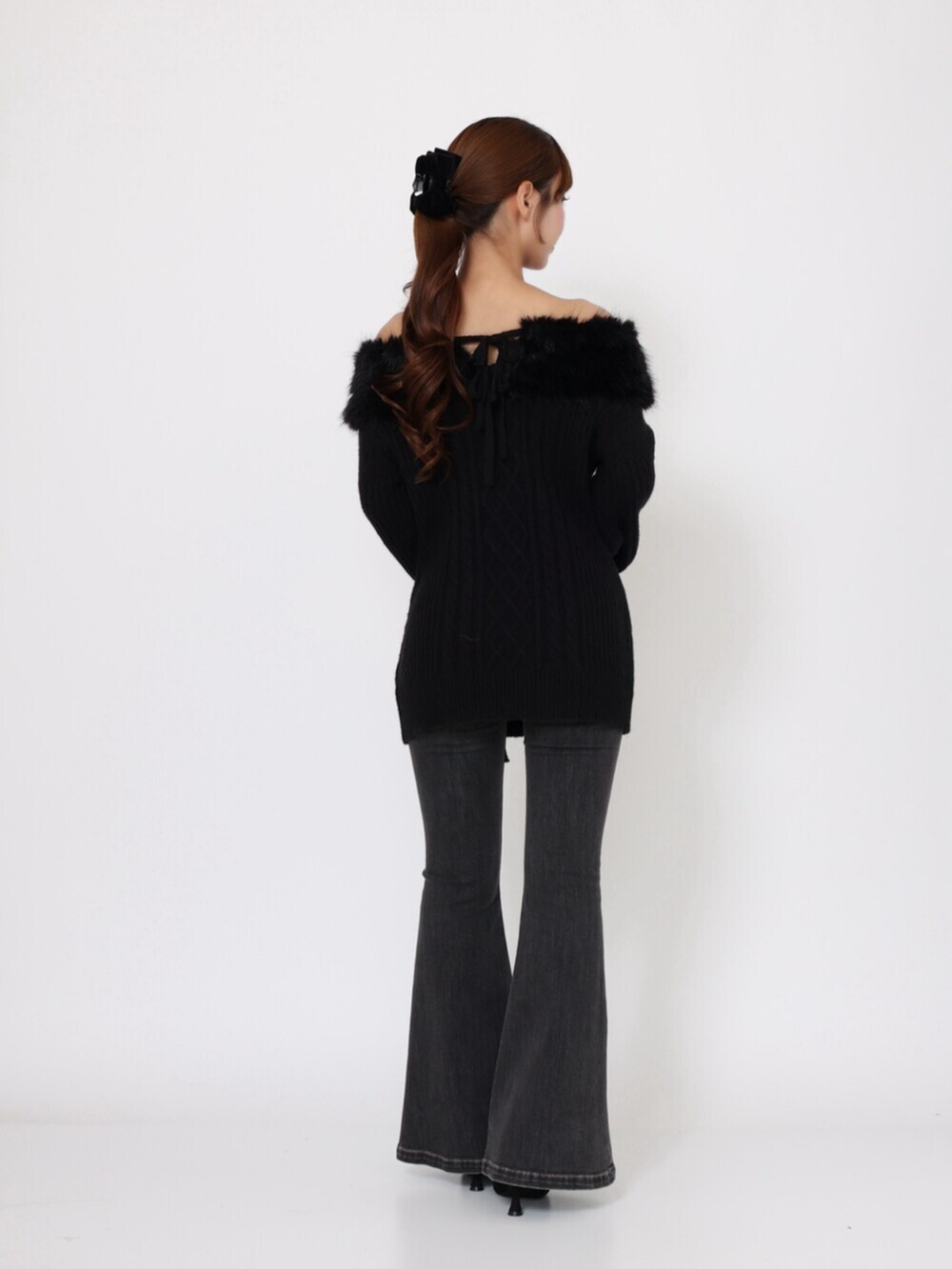 ブラック系のデニムパンツ、ブラック系のブーツ、ブラック系のニット/セーターを着用したレディースの秋コーディネートの4枚目の写真