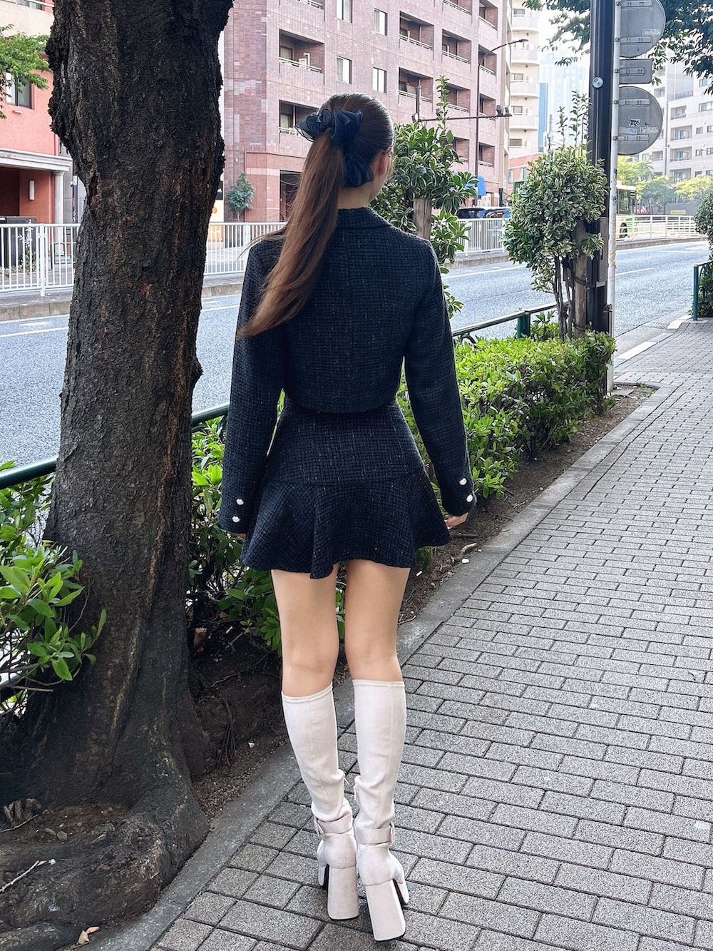 ブラック系のスカート、ブラック系のテーラードジャケット、ホワイト系のブーツを着用したレディースの秋コーディネートの3枚目の写真