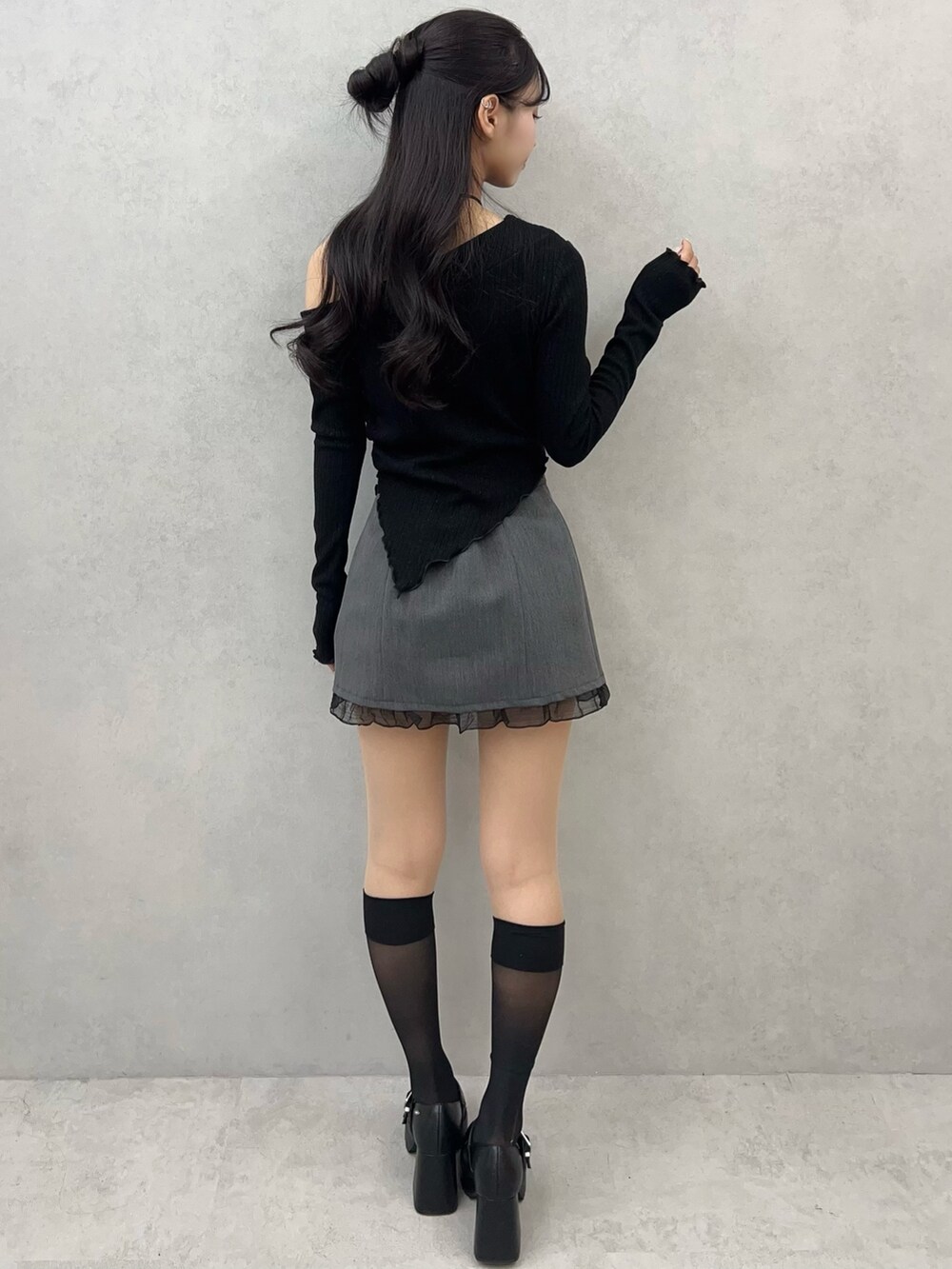 ブラック系のTシャツ/カットソー、グレー系のスカート、ブラック系のパンプスを着用したレディースの冬コーディネートの5枚目の写真