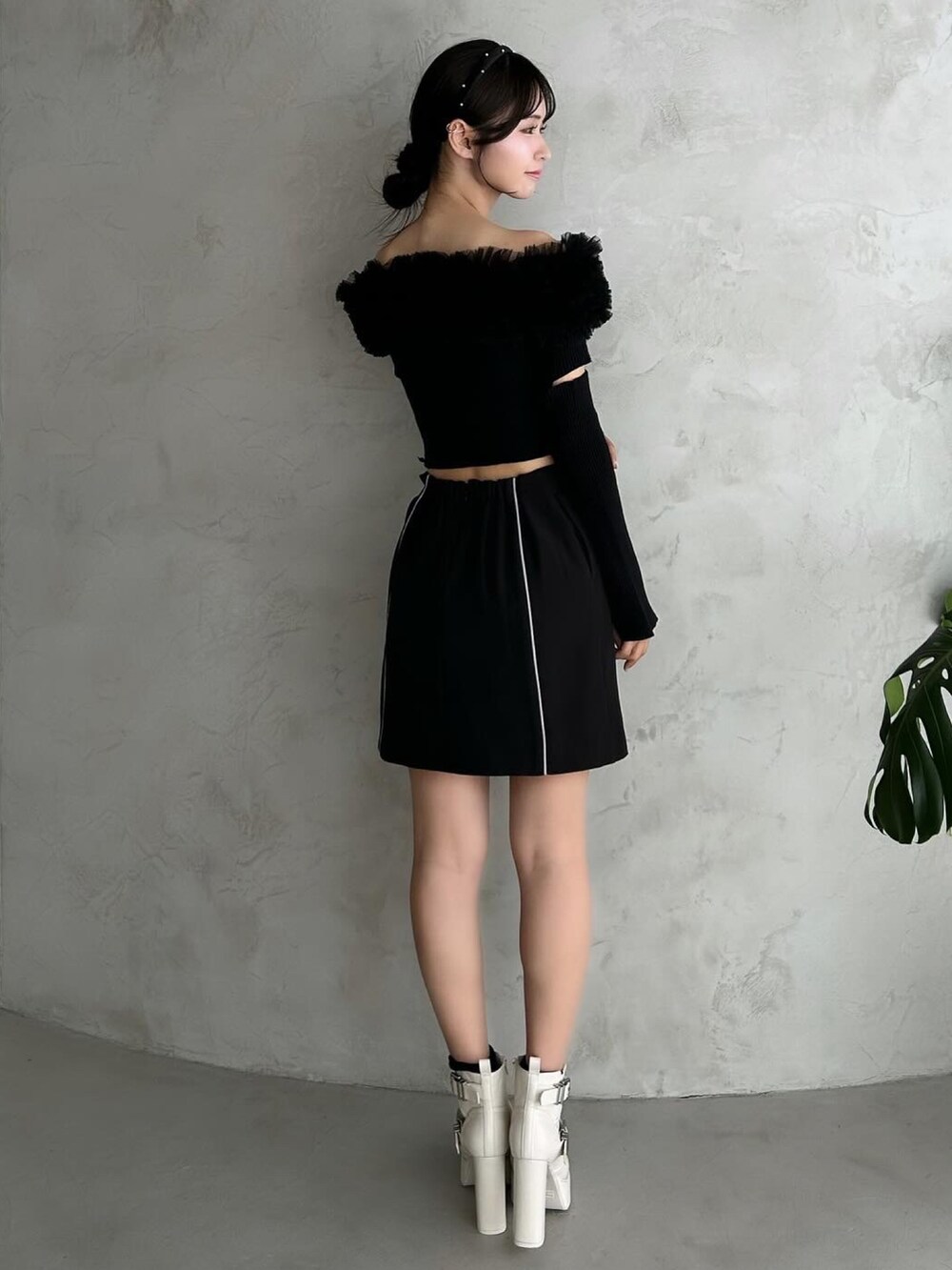 ブラック系のスカート、ブラック系のパンプス、ブラック系のニット/セーターを着用したレディースの秋コーディネートの4枚目の写真