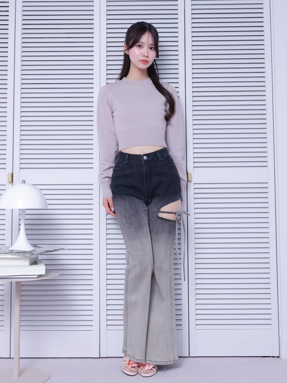 ブラック系のデニムパンツ、ピンク系のサンダル、ピンク系のニット/セーターを着用したレディースの春コーディネートの2枚目の写真