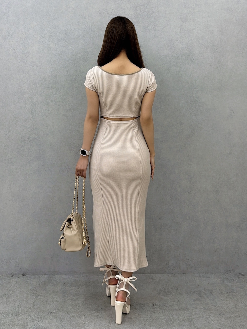 ベージュ系のワンピース、ベージュ系のバックパック/リュック、ホワイト系のサンダルを着用したレディースの春コーディネートの4枚目の写真