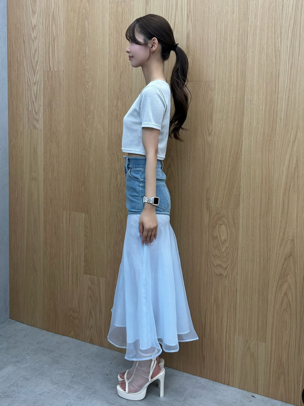 シルバー系のTシャツ/カットソー、ブルー系のデニムスカート、ホワイト系のサンダルを着用したレディースの夏コーディネートの2枚目の写真