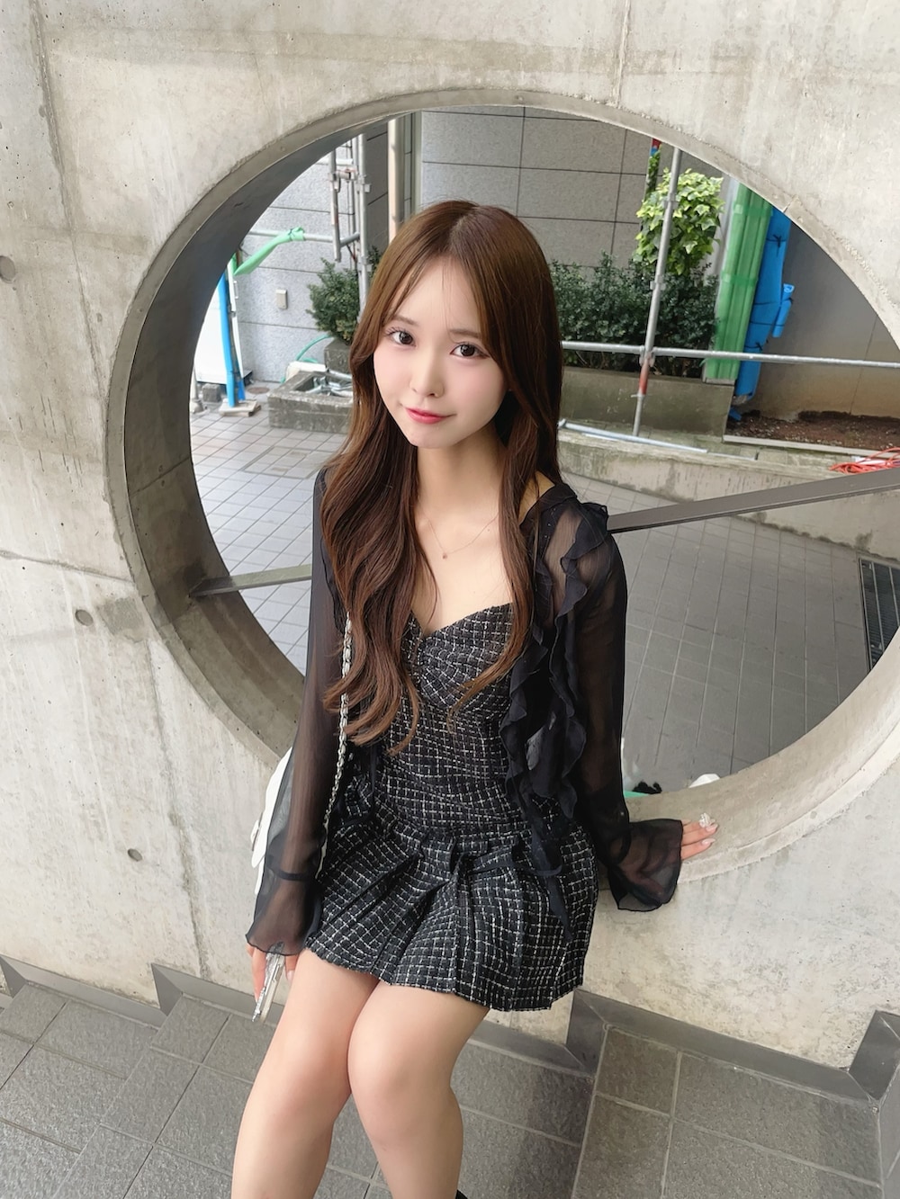 ブラック系のワンピース、ブラック系のサンダル、ホワイト系のショルダーバッグを着用したレディースの夏コーディネートの5枚目の写真