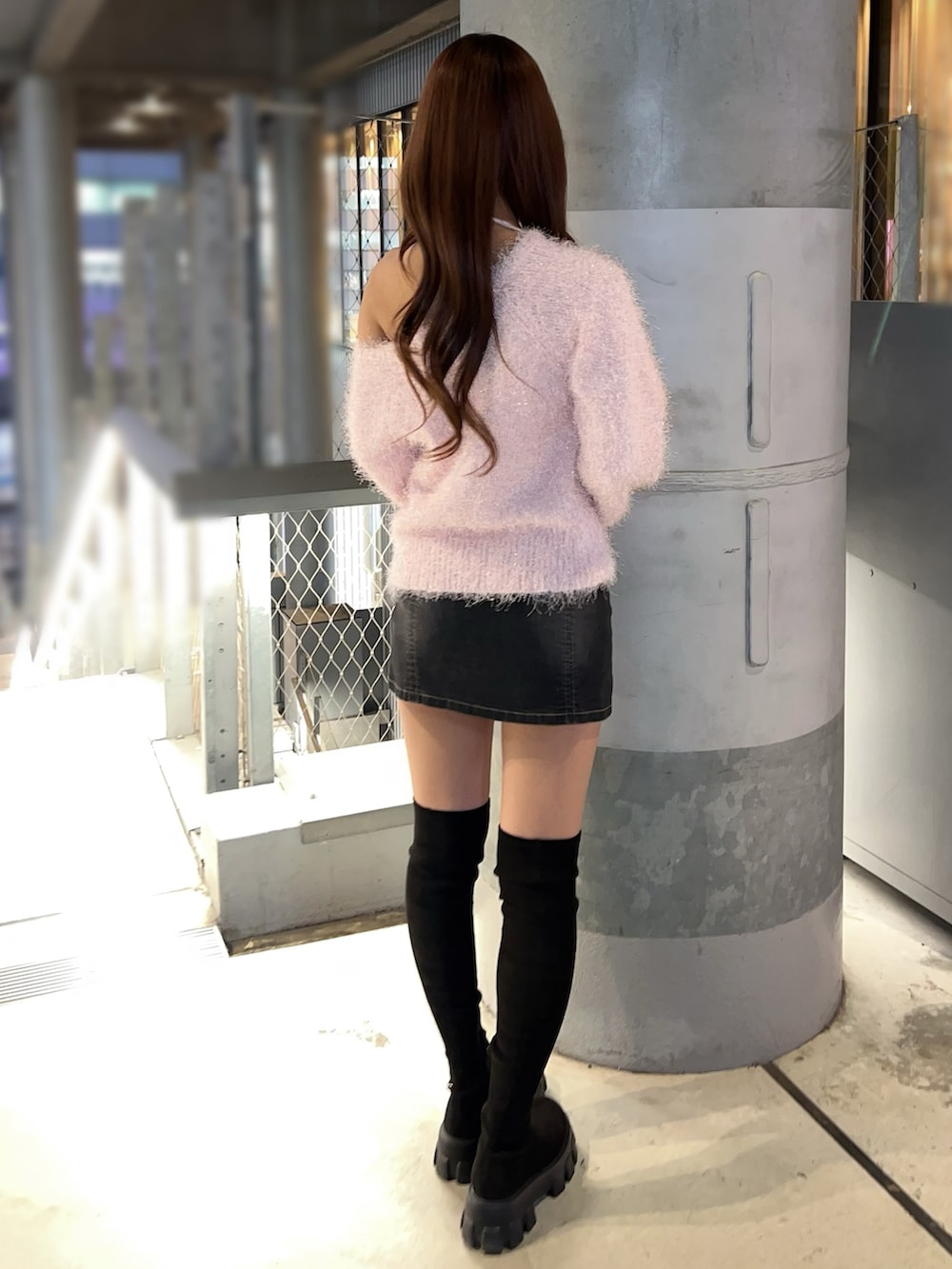 ピンク系のニット/セーター、ブラック系のデニムスカート、ブラック系のブーツを着用したレディースの冬コーディネートの4枚目の写真