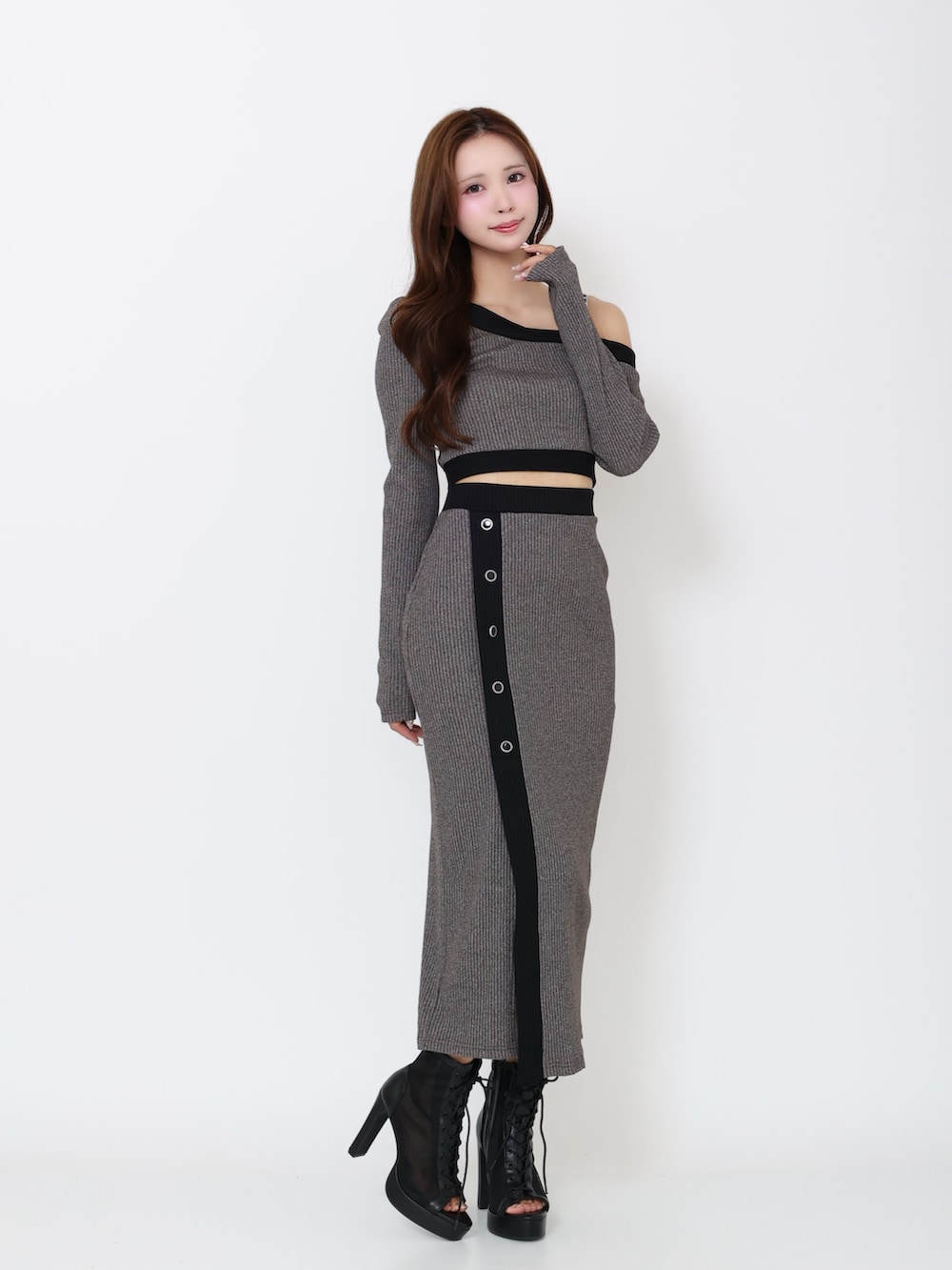 グレー系のTシャツ/カットソー、グレー系のスカート、ブラック系のブーツを着用したレディースの冬コーディネートの2枚目の写真