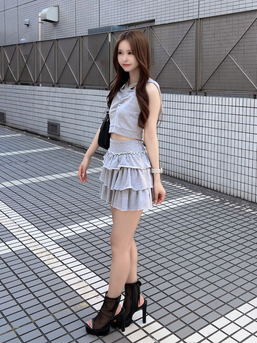 ブラック系のショルダーバッグ、グレー系のスカート、グレー系のキャミソールを着用したレディースの夏コーディネートの2枚目の写真