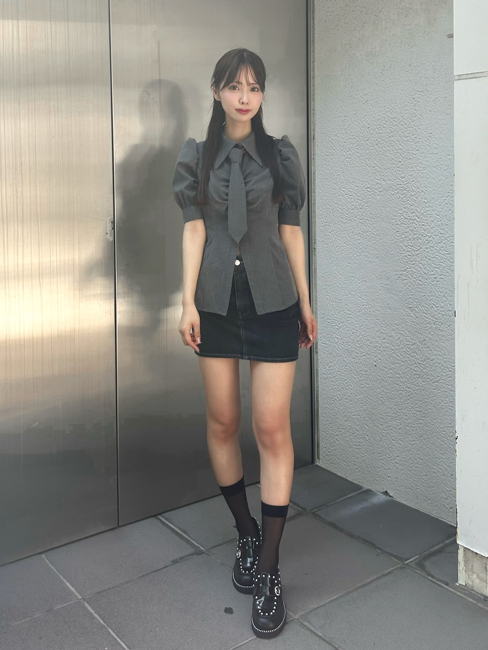 グレー系のシャツ/ブラウス、ブラック系のデニムスカート、ブラック系のローファーを着用したレディースの秋コーディネートの2枚目の写真