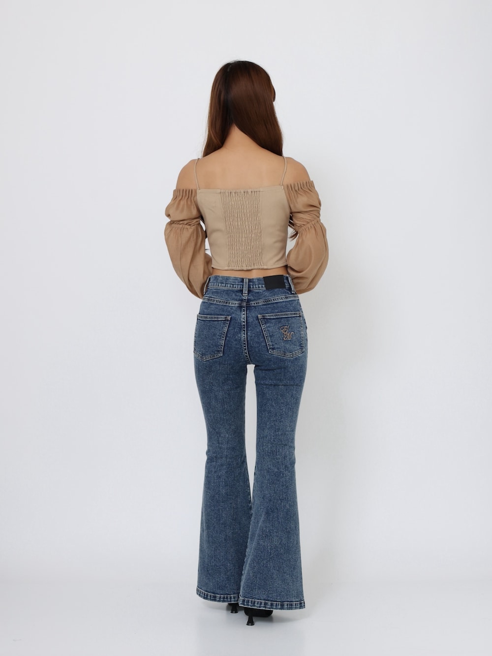ブラック系のブーツ、ブルー系のデニムパンツ、イエロー系のシャツ/ブラウスを着用したレディースの秋コーディネートの4枚目の写真