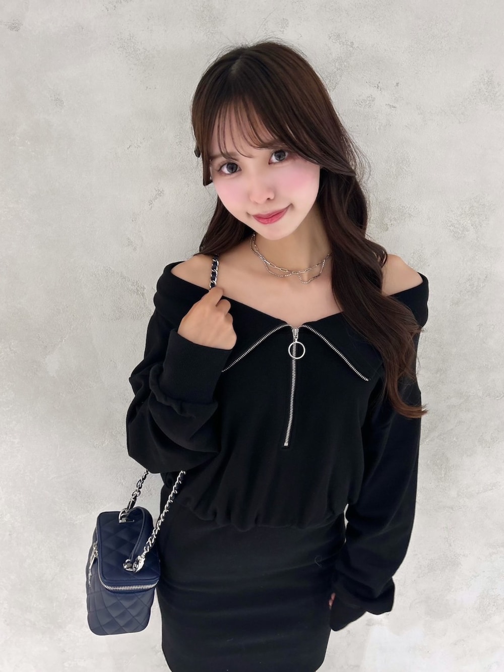 ブラック系のワンピース、ブルー系のハンドバッグ、シルバー系のネックレスを着用したレディースの秋コーディネートの4枚目の写真