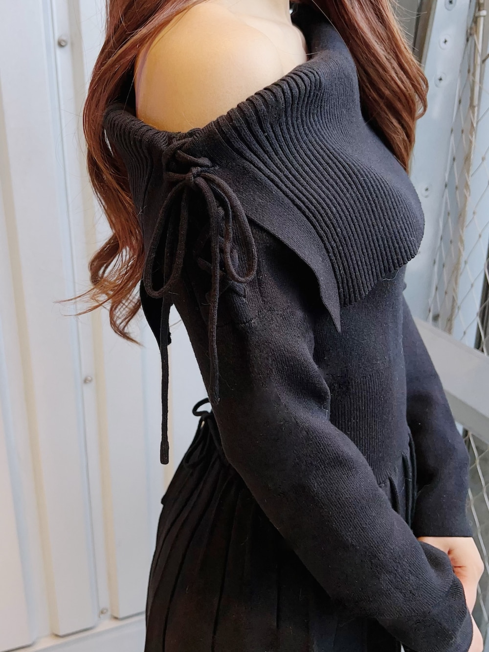 ブラック系のワンピース、ホワイト系のハンドバッグ、ブラック系のブーツを着用したレディースの冬コーディネートの7枚目の写真