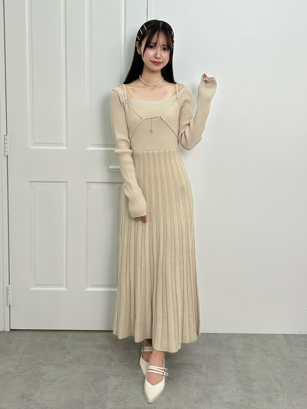 ホワイト系のワンピース、ホワイト系のパンプス、シルバー系のネックレスを着用したレディースの秋コーディネートの2枚目の写真