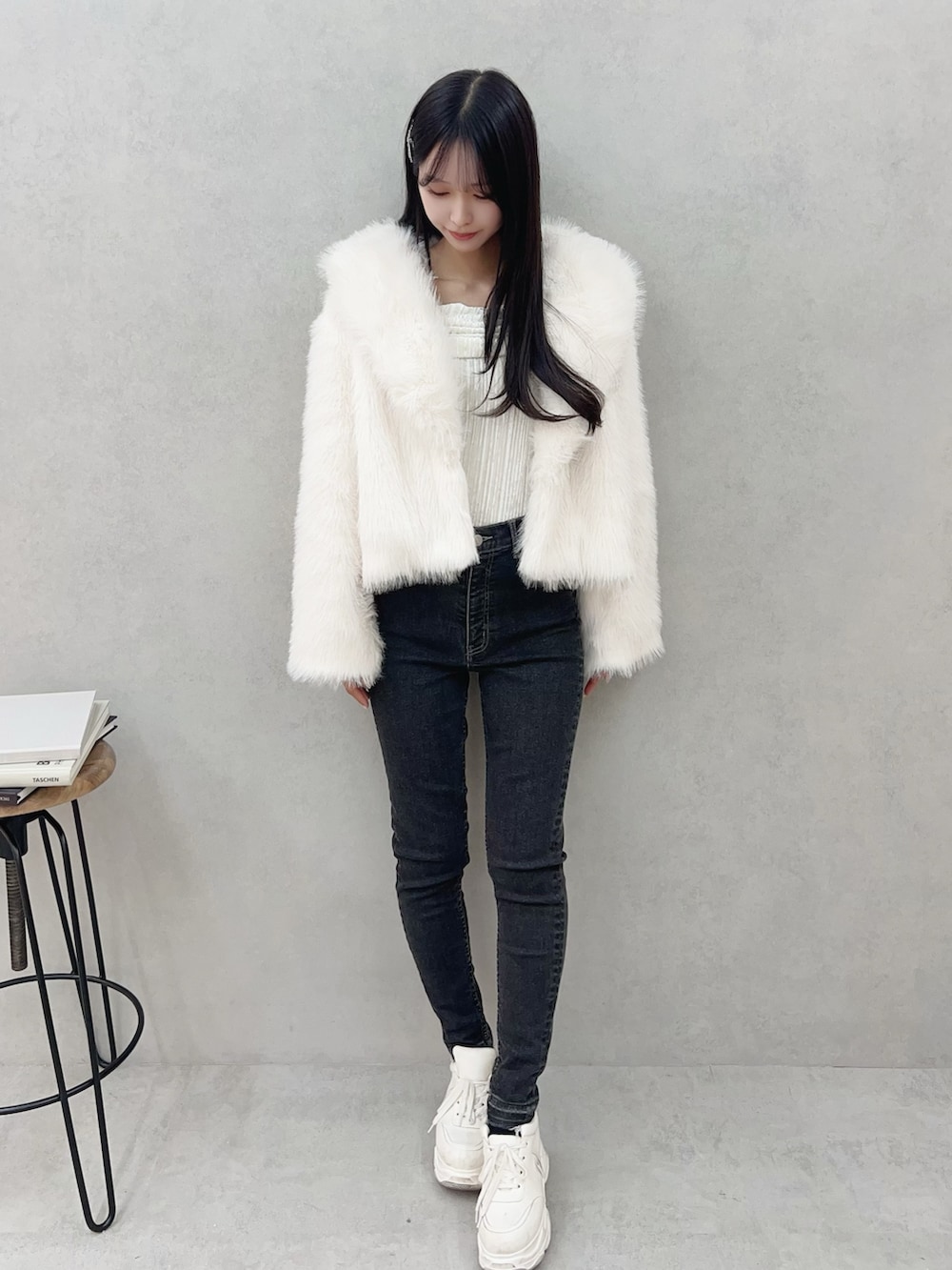 ホワイト系のその他アウター、ブラック系のデニムパンツ、ホワイト系のTシャツ/カットソーを着用したレディースの冬コーディネートの2枚目の写真