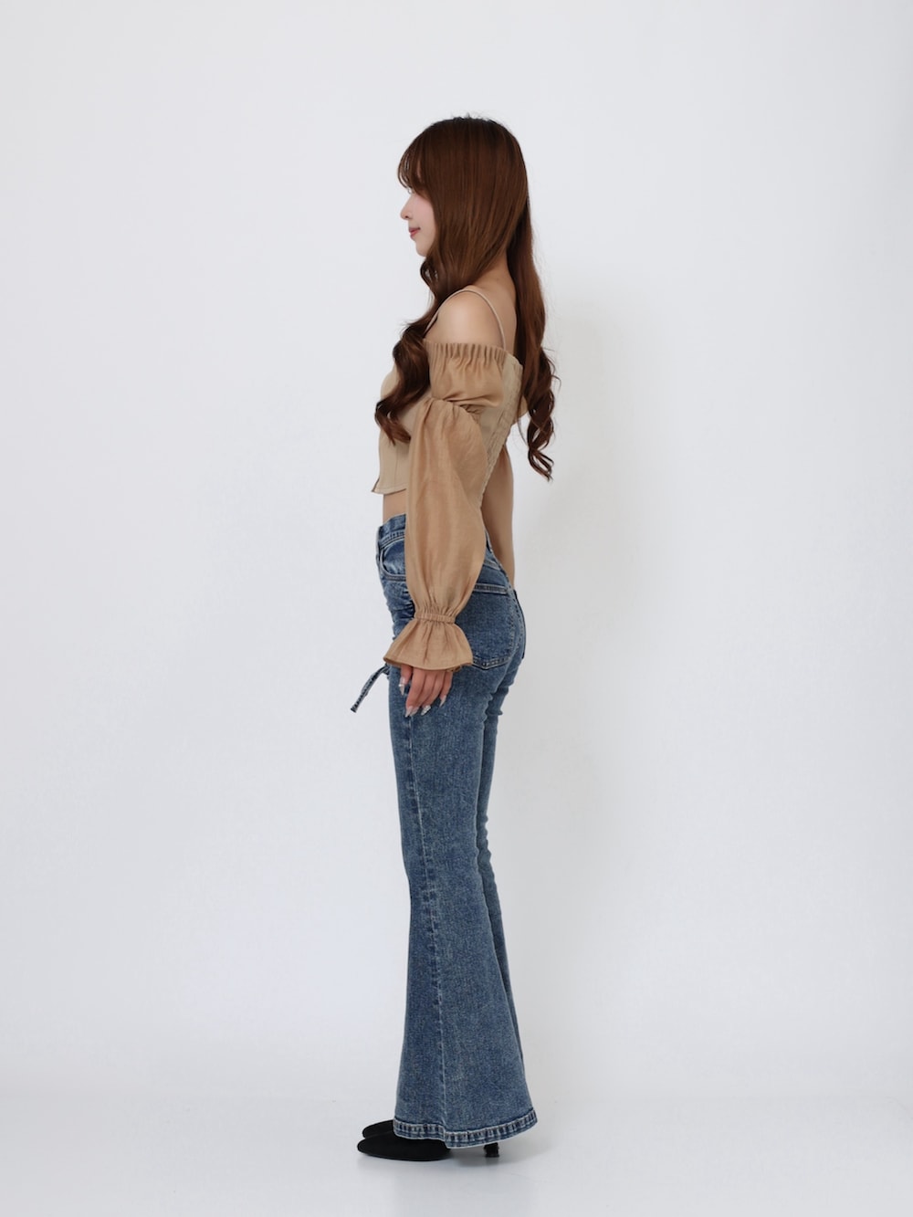 ブラック系のブーツ、ブルー系のデニムパンツ、イエロー系のシャツ/ブラウスを着用したレディースの秋コーディネートの3枚目の写真