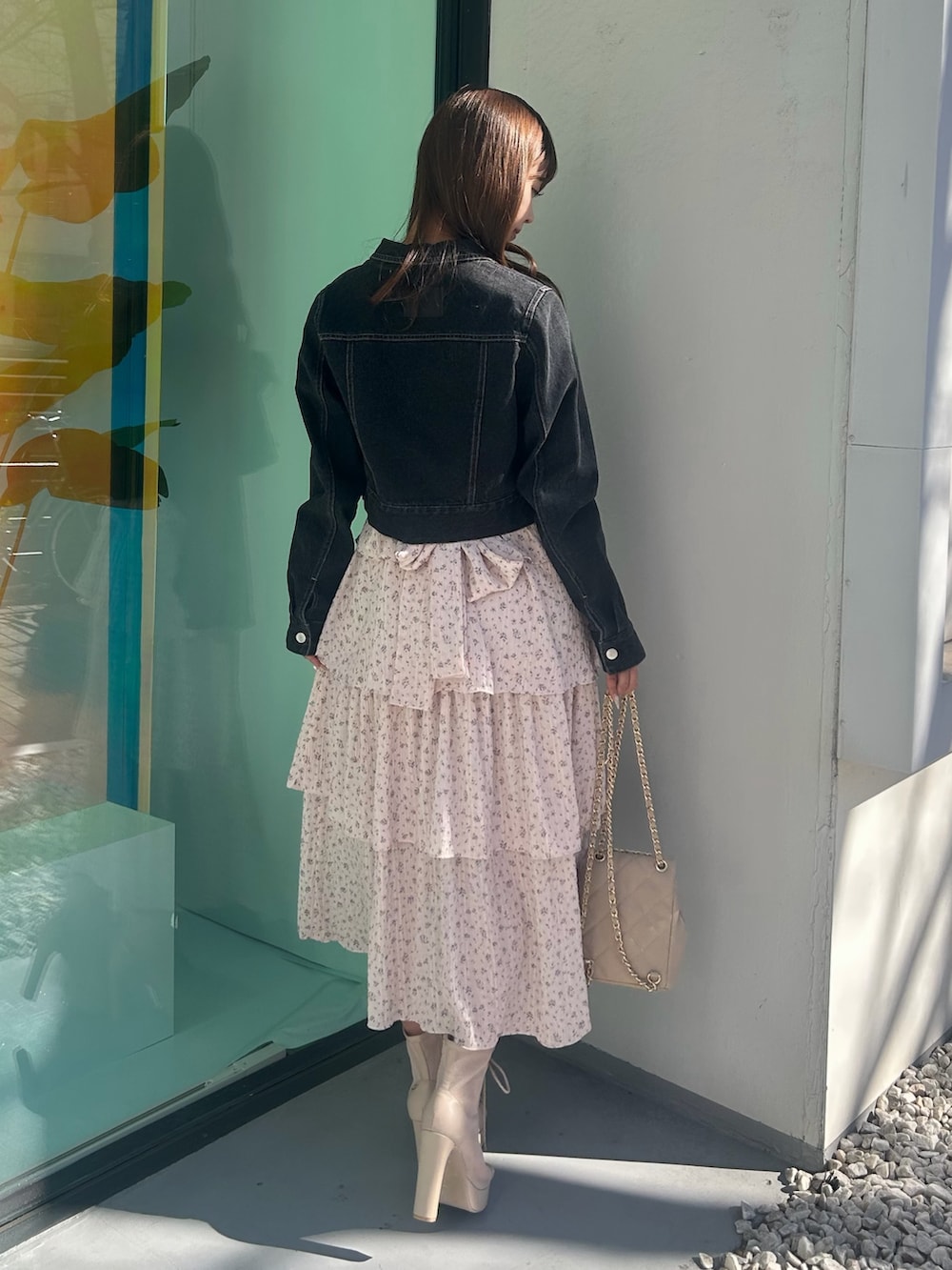 ピンク系のワンピース、ブラック系のデニムジャケット、ベージュ系のバックパック/リュックを着用したレディースの春コーディネートの4枚目の写真