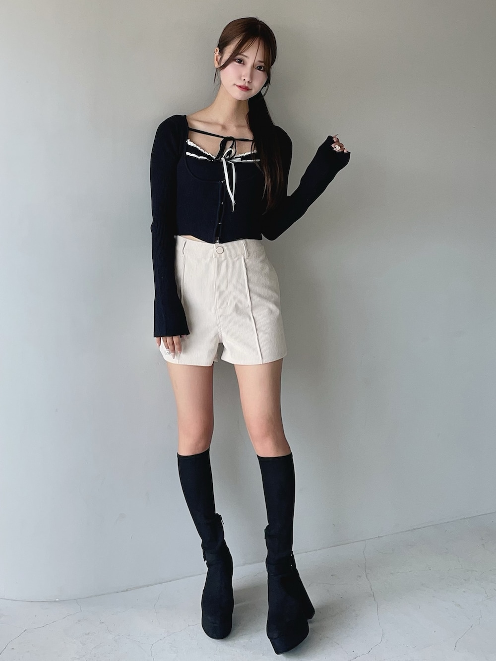 ホワイト系のその他パンツ、ブラック系のニット/セーター、ブラック系のブーツを着用したレディースの秋コーディネートの2枚目の写真