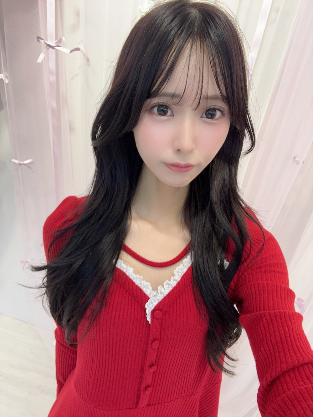 レッド系のワンピース、ホワイト系のショルダーバッグ、ブラック系のパンプスを着用したレディースの冬コーディネートの5枚目の写真