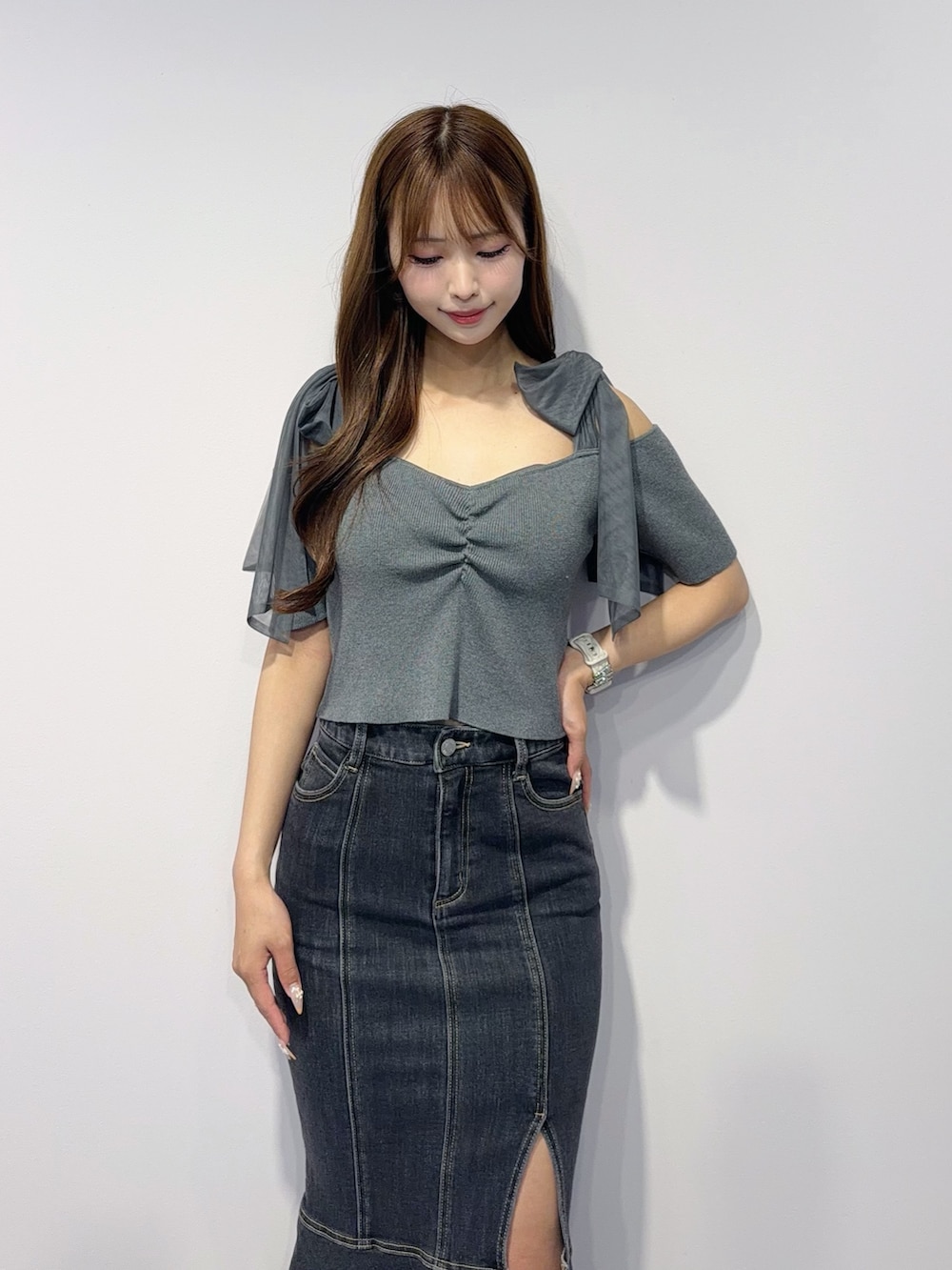 ブラック系のデニムスカート、グレー系のTシャツ/カットソー、ブラック系のサンダルを着用したレディースの春コーディネートの5枚目の写真