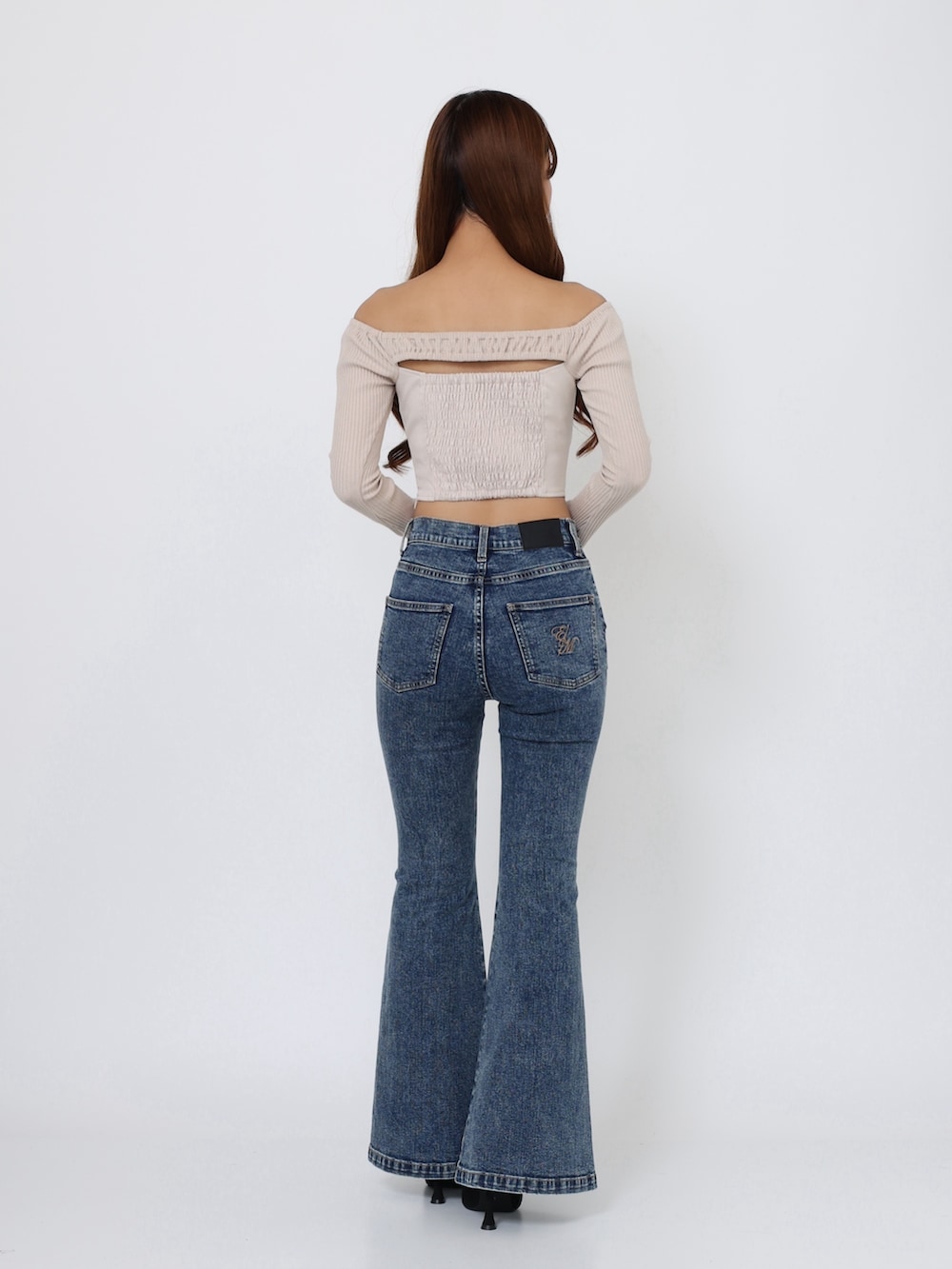 ブラック系のブーツ、ベージュ系のTシャツ/カットソー、ブルー系のデニムパンツを着用したレディースの秋コーディネートの4枚目の写真