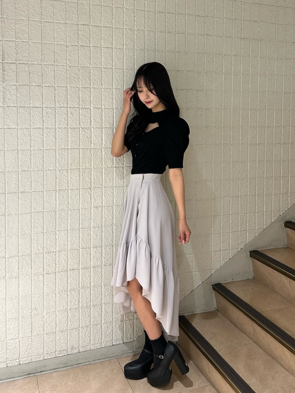 ブラック系のTシャツ/カットソー、グレー系のスカート、ブラック系のパンプスを着用したレディースの春コーディネートの2枚目の写真