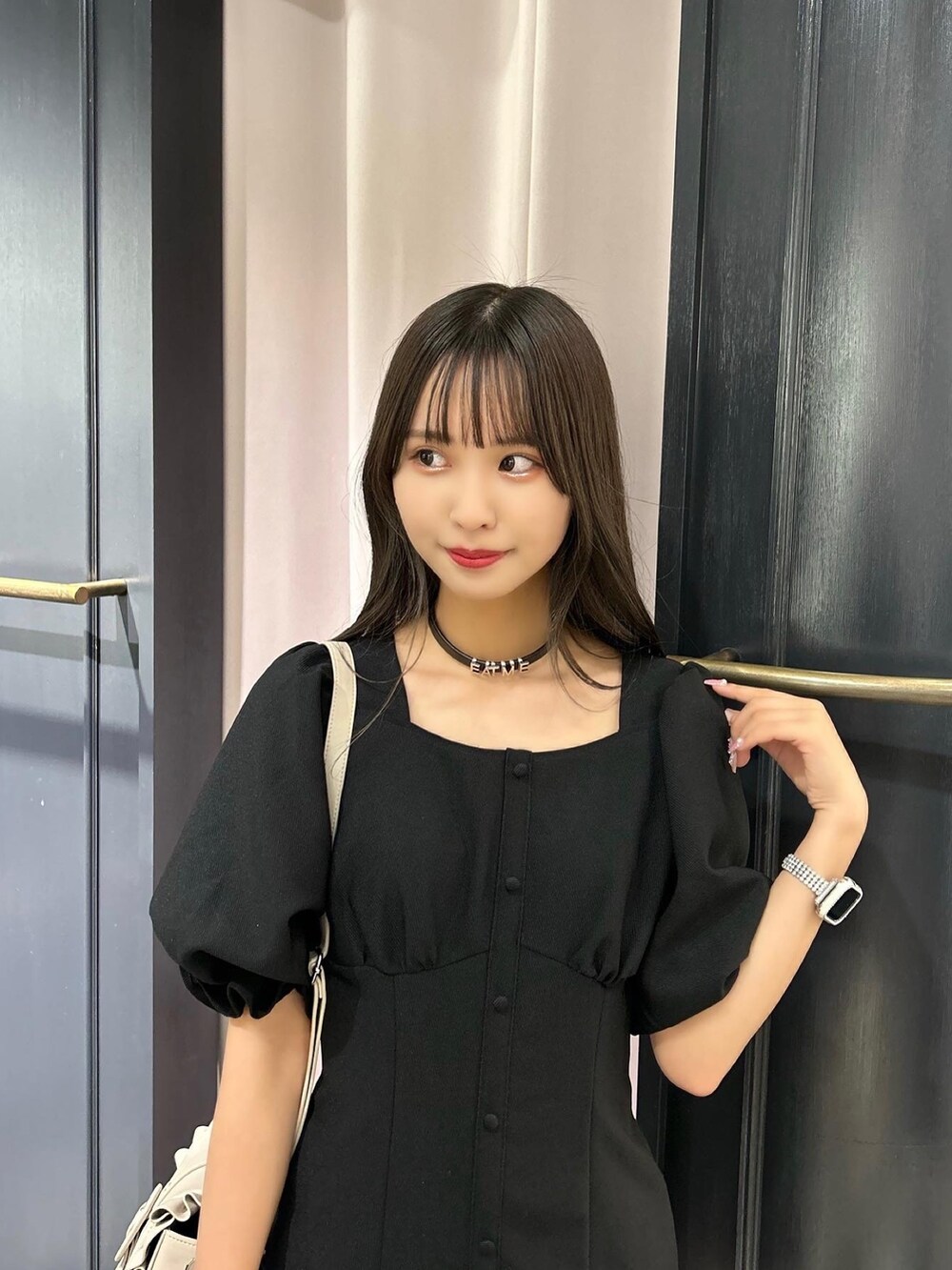 ブラック系のワンピース、ベージュ系のショルダーバッグ、その他のパンプスを着用したレディースの春コーディネートの5枚目の写真