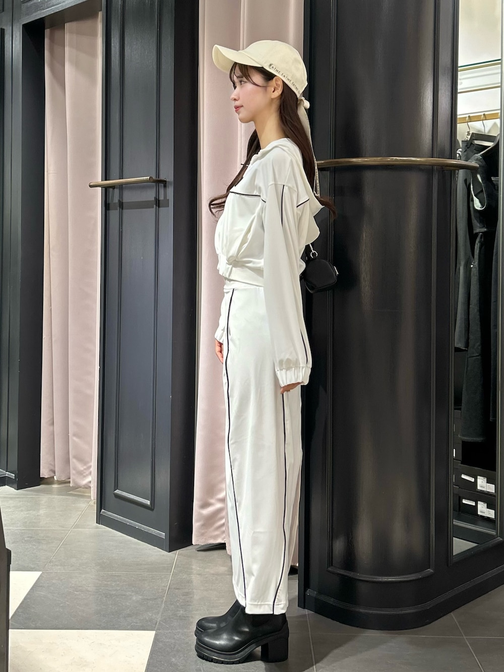 ホワイト系のナイロンジャケット、ホワイト系のスカート、ブラック系のショルダーバッグを着用したレディースの秋コーディネートの2枚目の写真