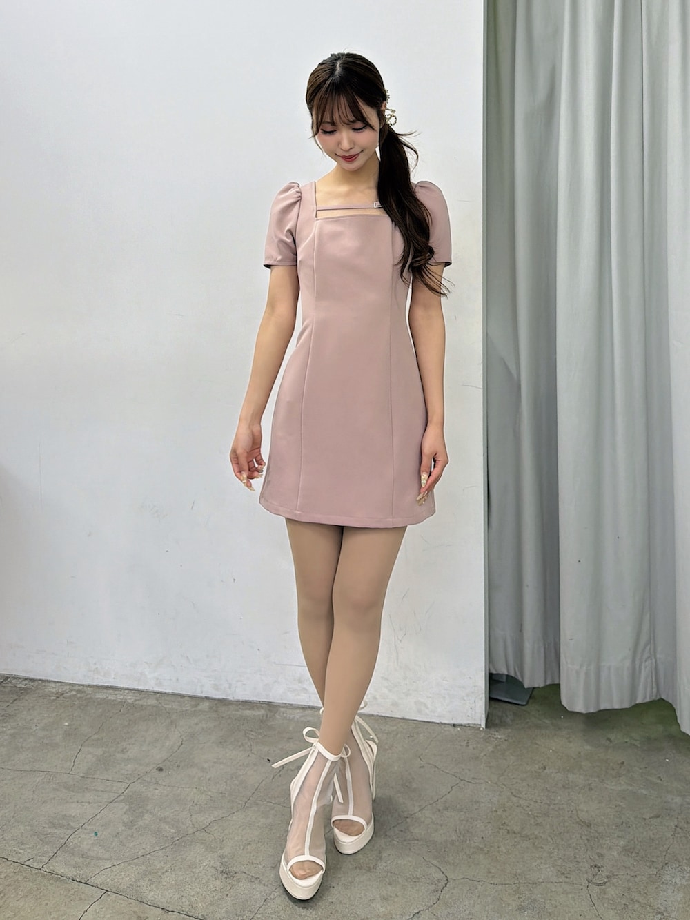 ピンク系のワンピース、ホワイト系のサンダル、ゴールド系のバレッタ/ヘアクリップを着用したレディースの春コーディネートの2枚目の写真