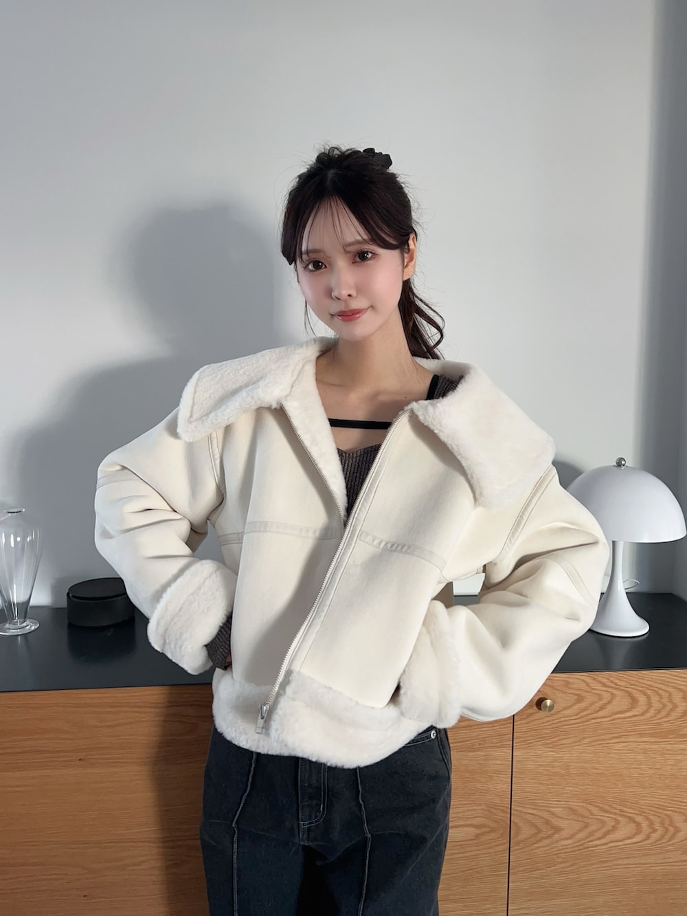 ホワイト系のブルゾン、ブラック系のブーツ、グレー系のTシャツ/カットソーを着用したレディースの冬コーディネートの6枚目の写真