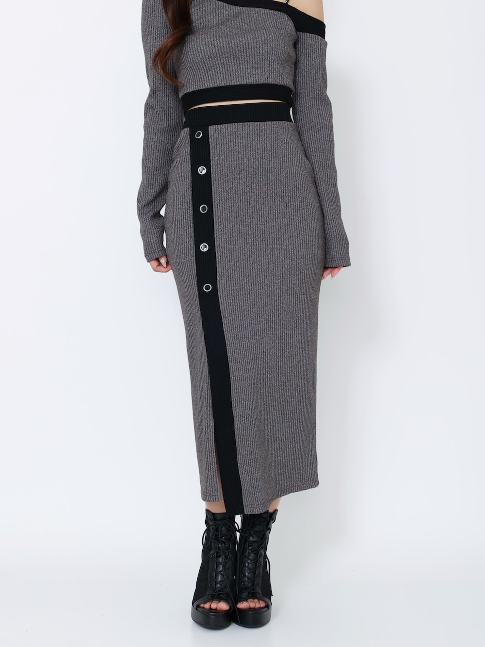 グレー系のTシャツ/カットソー、グレー系のスカート、ブラック系のブーツを着用したレディースの冬コーディネートの7枚目の写真