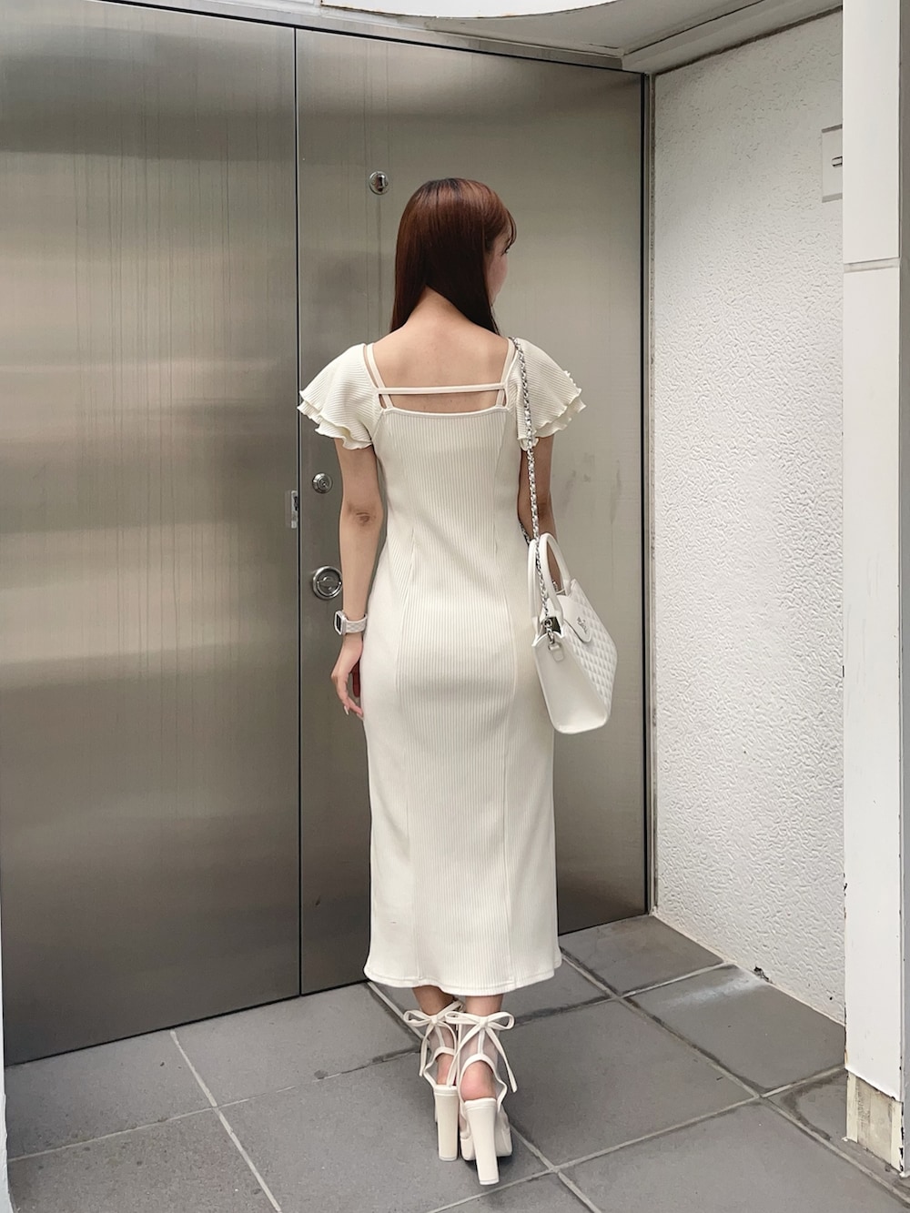 ホワイト系のワンピース、ホワイト系のハンドバッグ、ホワイト系のサンダルを着用したレディースの夏コーディネートの4枚目の写真