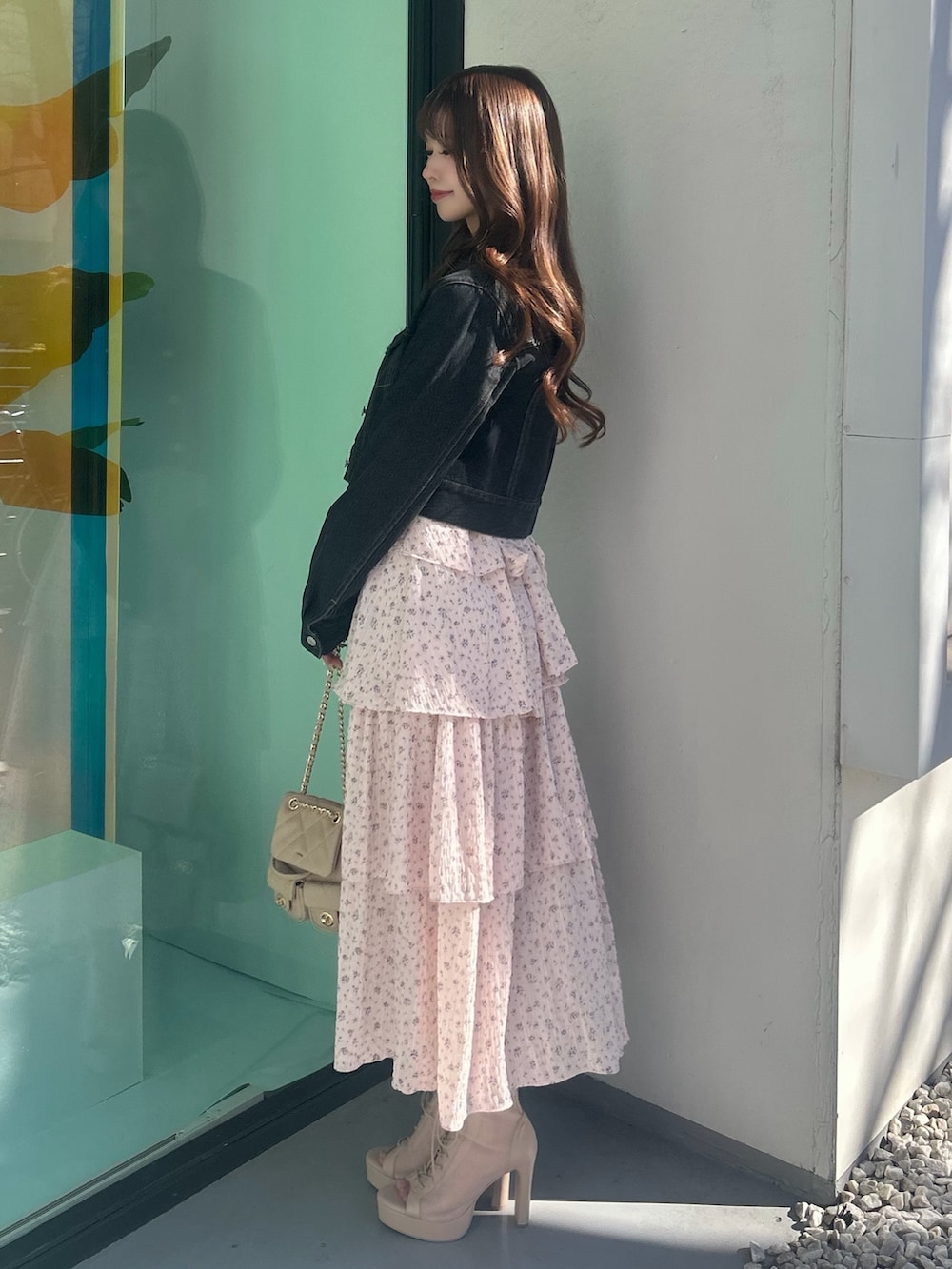 ピンク系のワンピース、ブラック系のデニムジャケット、ベージュ系のバックパック/リュックを着用したレディースの春コーディネートの3枚目の写真