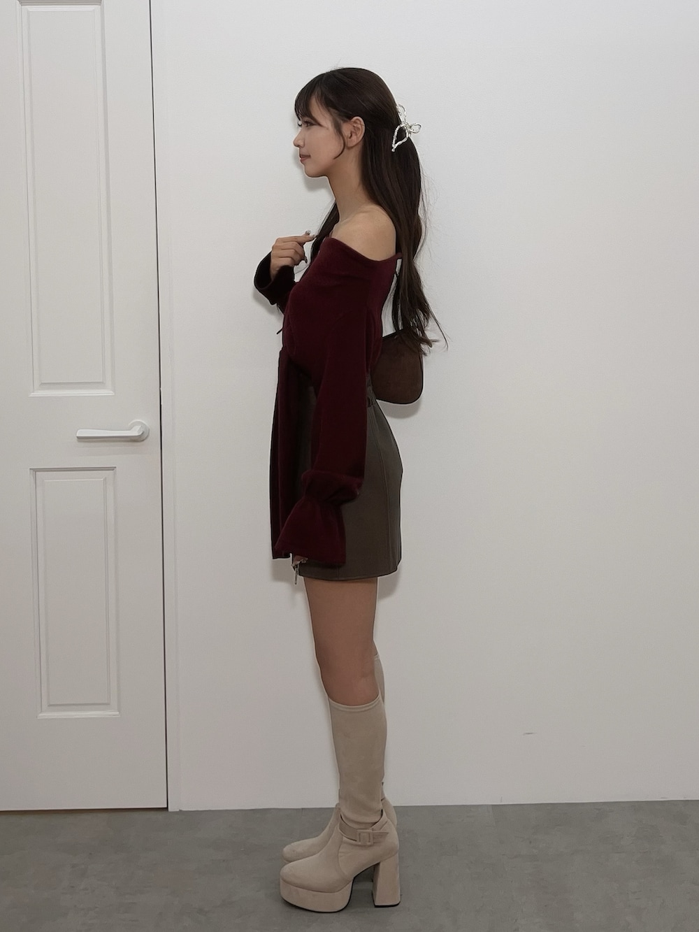 レッド系のTシャツ/カットソー、ブラウン系のスカート、ブラック系のブーツを着用したレディースの冬コーディネートの3枚目の写真