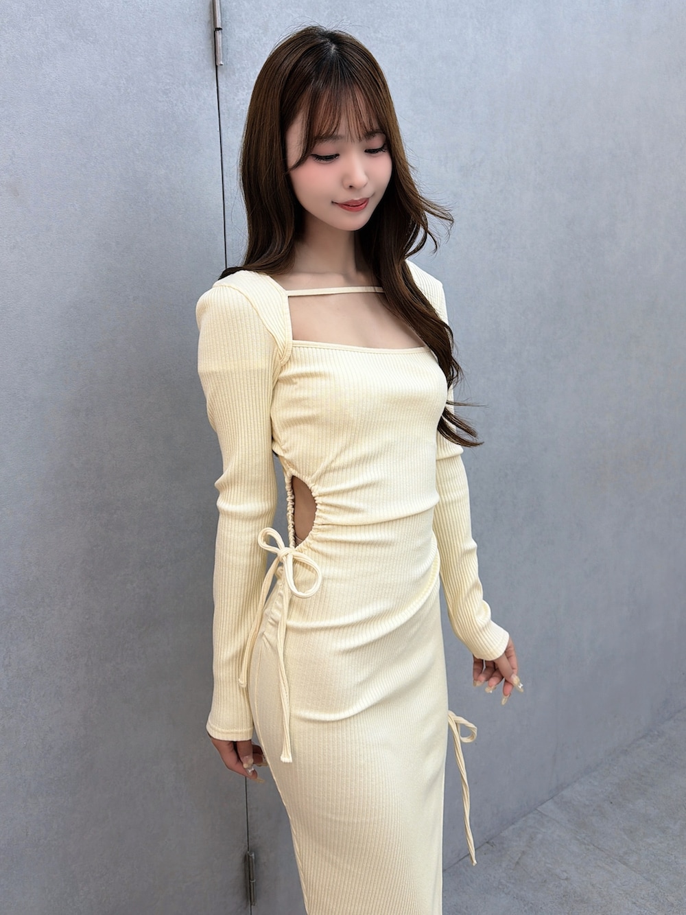 イエロー系のワンピース、ホワイト系のサンダルを着用したレディースの冬コーディネートの6枚目の写真