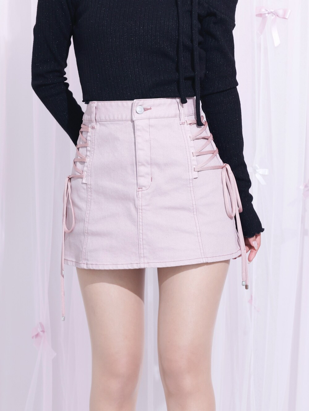 ピンク系のデニムスカート、ブラック系のTシャツ/カットソー、ブラック系のサンダルを着用したレディースの冬コーディネートの4枚目の写真