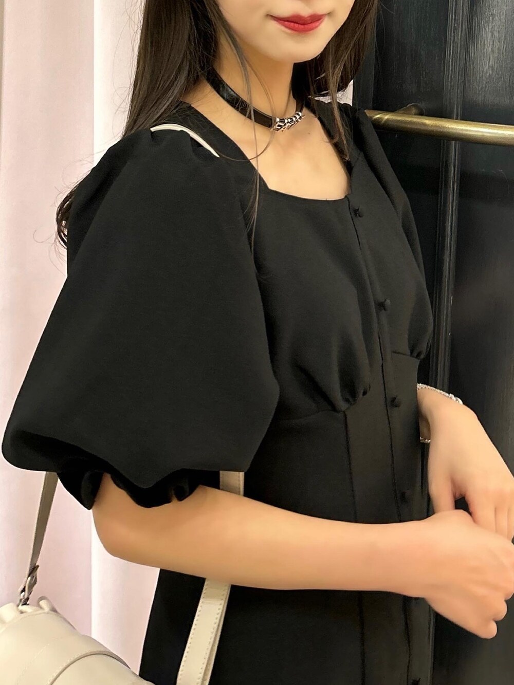 ブラック系のワンピース、ベージュ系のショルダーバッグ、その他のパンプスを着用したレディースの春コーディネートの4枚目の写真