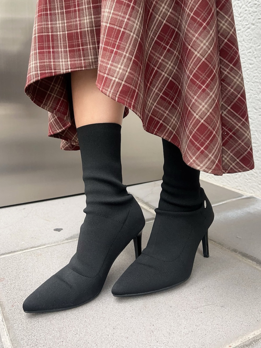 レッド系のワンピース、ブラック系のブーツ、レッド系のショルダーバッグを着用したレディースの秋コーディネートの6枚目の写真