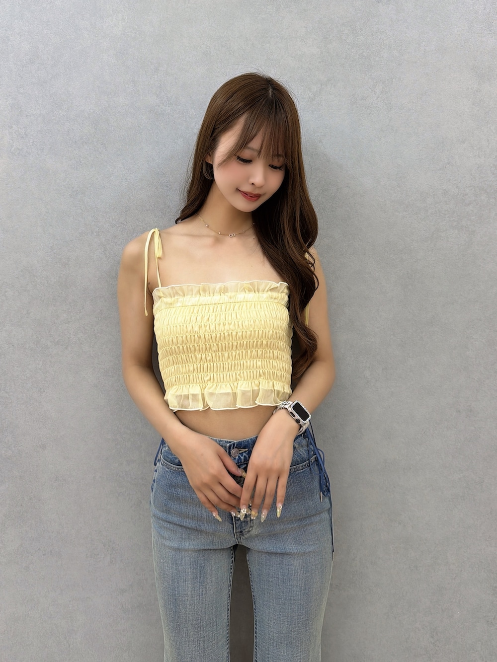 ブルー系のデニムパンツ、イエロー系のシャツ/ブラウス、ホワイト系のサンダルを着用したレディースの春コーディネートの6枚目の写真