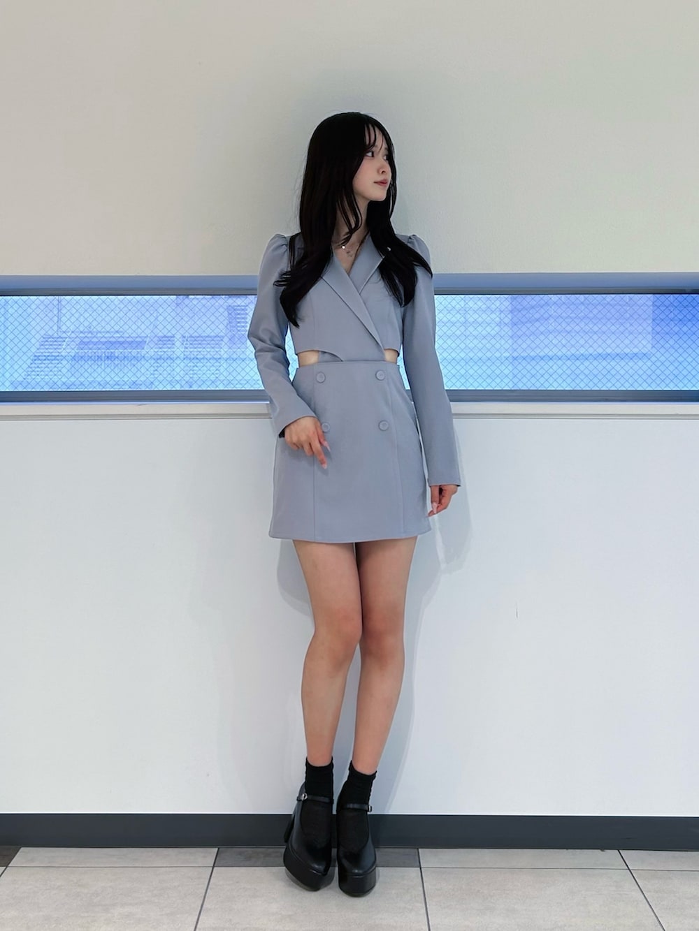 ブルー系のワンピース、ブラック系のパンプス、シルバー系のネックレスを着用したレディースの冬コーディネートの2枚目の写真